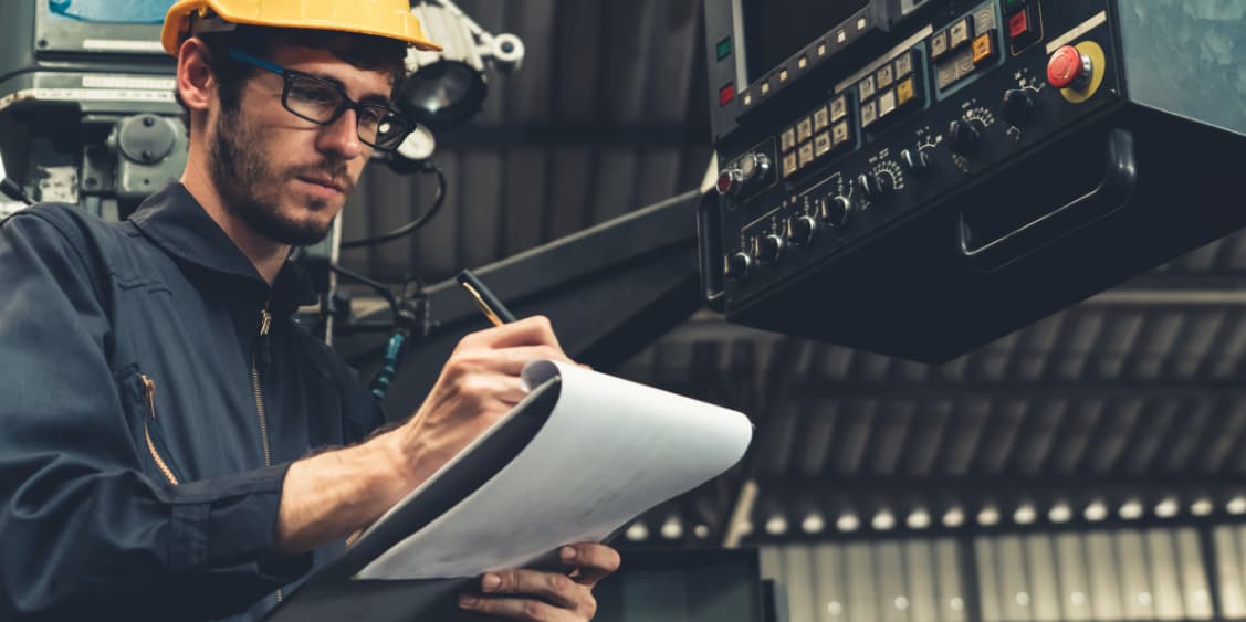 Skilful factory worker working with clipboard to do job procedure checklist . Factory production line occupation quality control concept .