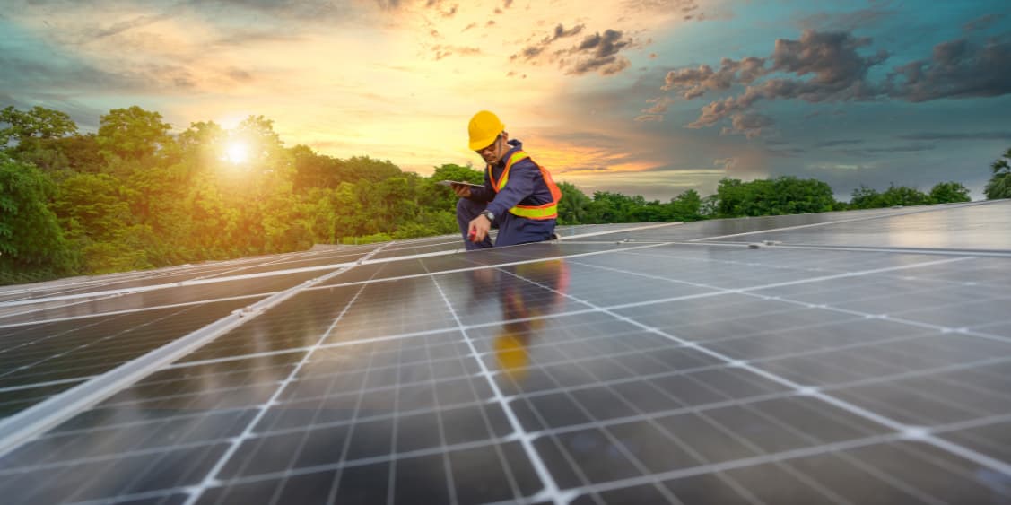 Worker installing Solar panels, for better sustainability.