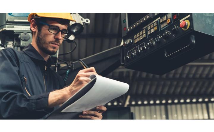 Skilful factory worker working with clipboard to do job procedure checklist . Factory production line occupation quality control concept .